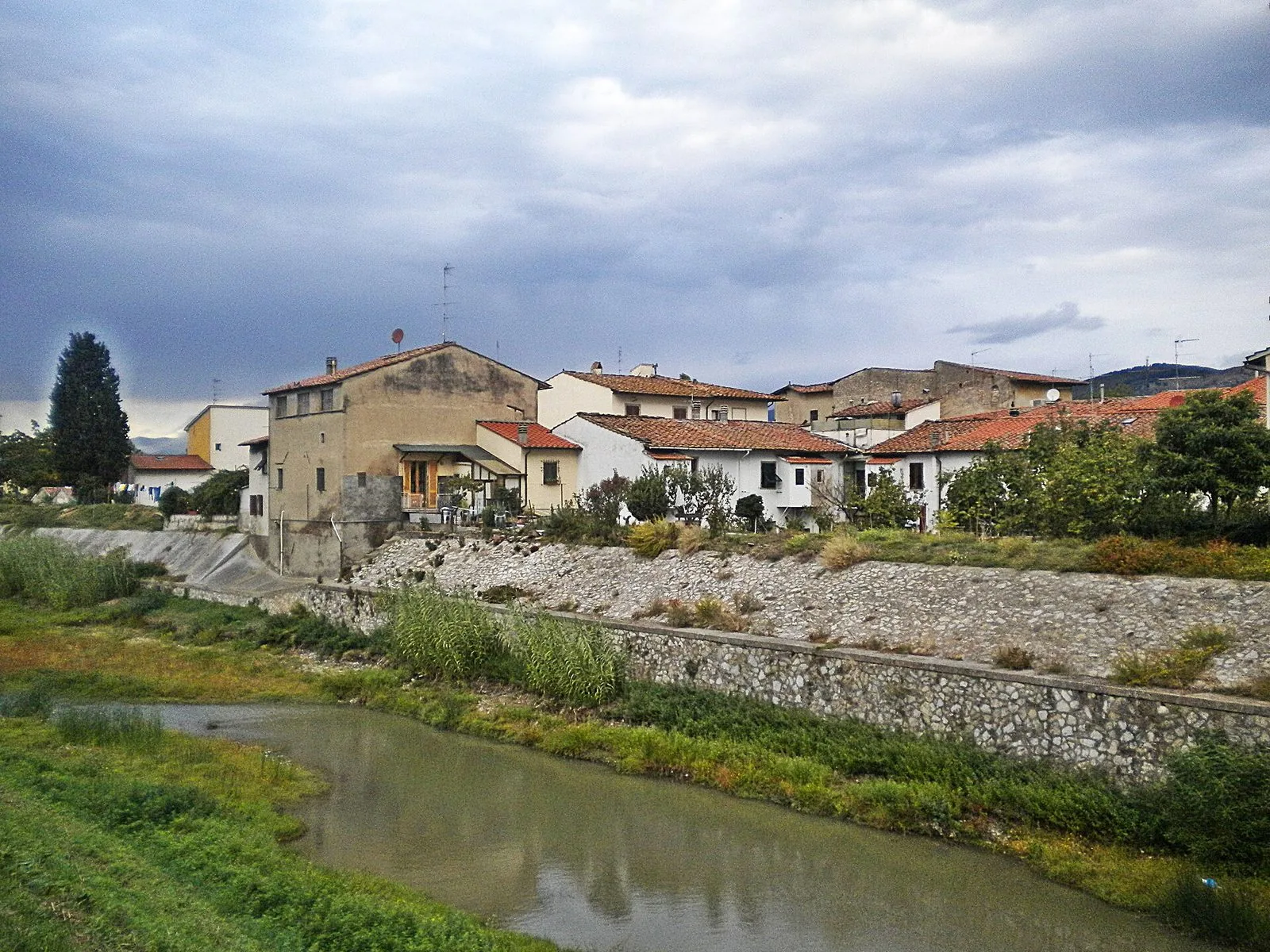 Il fiume Bisenzio nella piana fiorentina, con le case di Capalle sulla riva