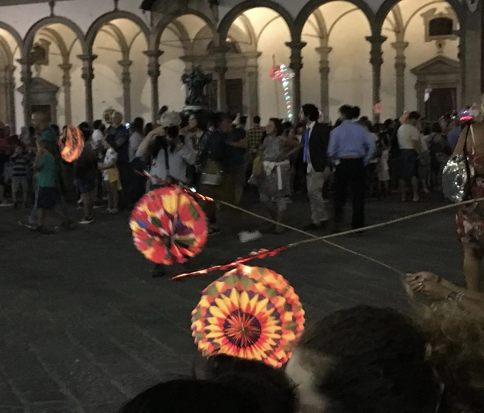 Lanterne di carta colorate della Rificolona appese sotto un loggiato a Firenze